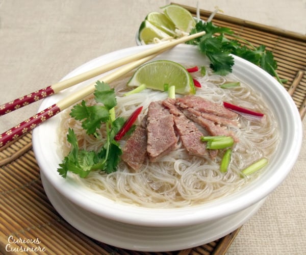 加香料的牛肉肉汤，米粉和薄片牛肉在这个舒适的亚洲菜中举起。