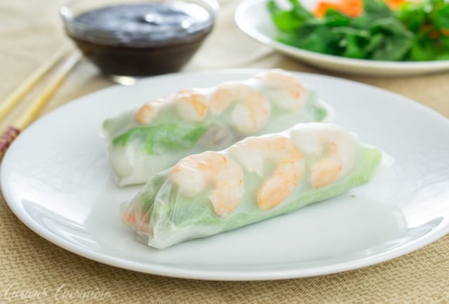 两个越南春天卷用虾和绿色在一块白色板材。