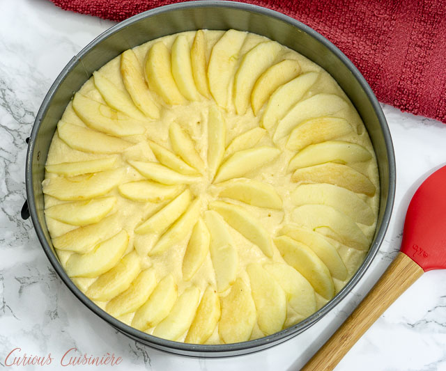 在烘烤Apfelkuchen，德国苹果蛋糕之前，苹果在春天形状的平底锅中分层在春天形式的平底锅上。| www.CuriousCuisiniere.com
