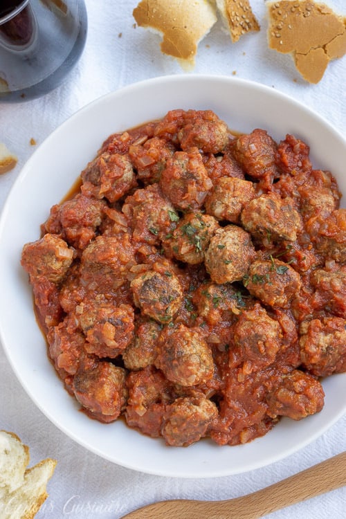 西班牙肉丸(Albondigas)是西班牙小吃店的传统小吃。无论您是为开胃菜,小吃派对还是晚餐主菜服务,这些小肉丸都在美味的番茄酱中是完美的,享用一杯红酒。| www.CuriousCuisiniere.com