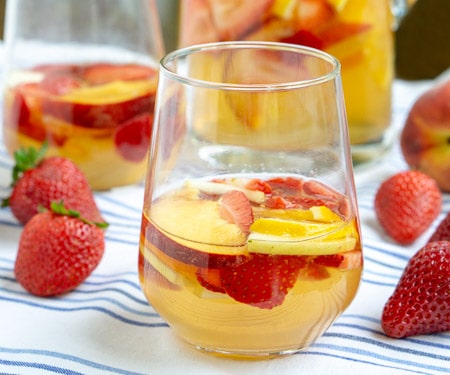 这款草莓桃萨格里亚州是一种乐趣的西班牙白桑格里亚乐趣。新鲜水果，清脆的白葡萄酒，以及一片白兰地的飞溅让这是一个夏天的最爱！| www.CuriousCuisiniere.com