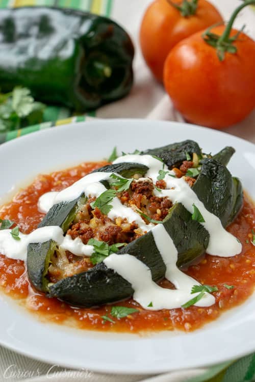 烤辣椒Rellenos,里面填满了西班牙辣香肠、米饭和融化的奶酪,这是一种简单的方法,既可以享受墨西哥酿辣椒,又不需要油炸。| www.CuriousCuisiniere.com