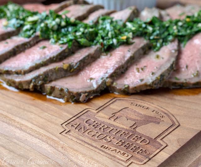 切的顶面烤烤肉用chimichurri调味汁在一个认证的安斯牛肉品牌烙画的木切板。
