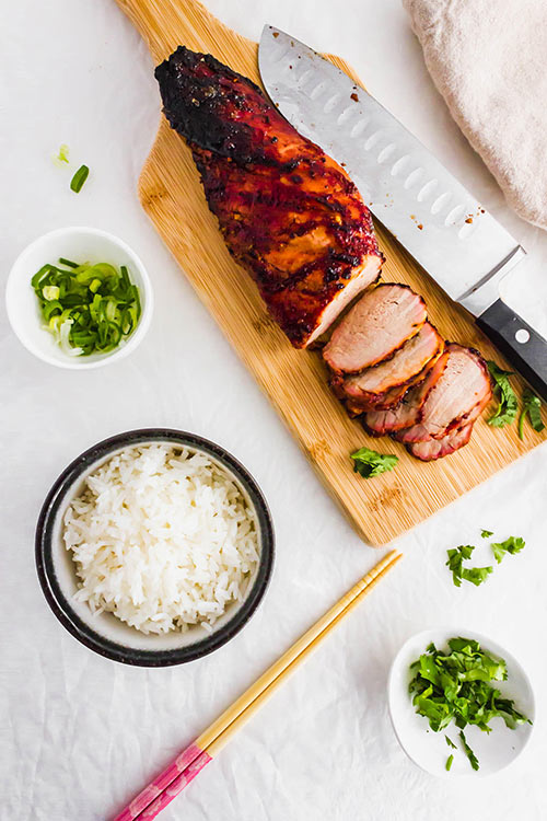 Char Siu中文烧烤猪中脊肉用筷子和米的顶上的看法。| www.CuriousCuisiniere.com
