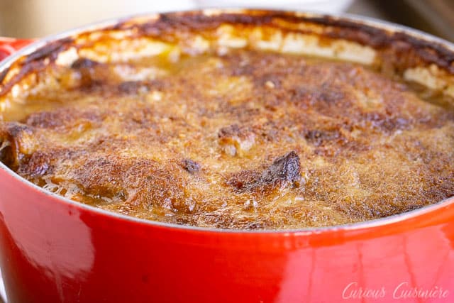 在红色荷兰烤箱的一个金黄螺纹顶部的cassoulet。| www.CuriousCuisiniere.com