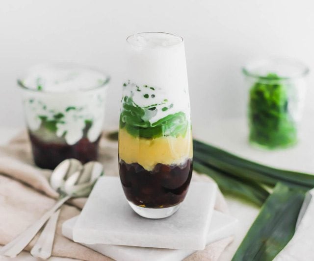 俯视图的cendol，马来西亚的pandan果冻，层与红色红豆，黄色绿豆，和椰子汁在一个玻璃杯。