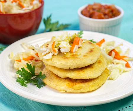 萨尔瓦多的pupusas，芝士馅玉米饼，上面的小图像上堆放着卷心菜沙拉