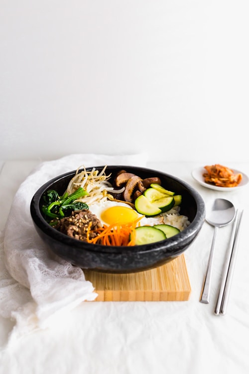 韩国Bibimbap混合的米饭碗里有一个流鼻涕的鸡蛋