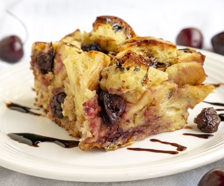 这种樱桃面包布丁的香脂釉给它带来了一种意想不到的明亮风味。这个食谱是用不新鲜的面包做美味的早餐或甜点的完美方法!| www.CuriousCuisiniere.com