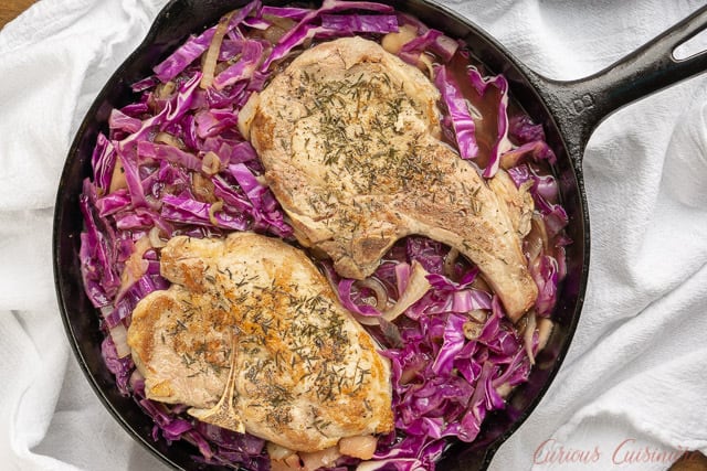 这款受德国启发的煎锅配方是苹果酒猪排配红卷心菜，将秋天的味道带到你的餐桌上。所有的东西都被炖得鲜嫩可口!| www.CuriousCuisiniere.comgydF4y2Ba