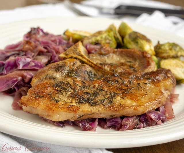 这款受德国启发的煎锅配方是苹果酒猪排配红卷心菜，将秋天的味道带到你的餐桌上。所有的东西都被炖得鲜嫩可口!| www.CuriousCuisiniere.comgydF4y2Ba