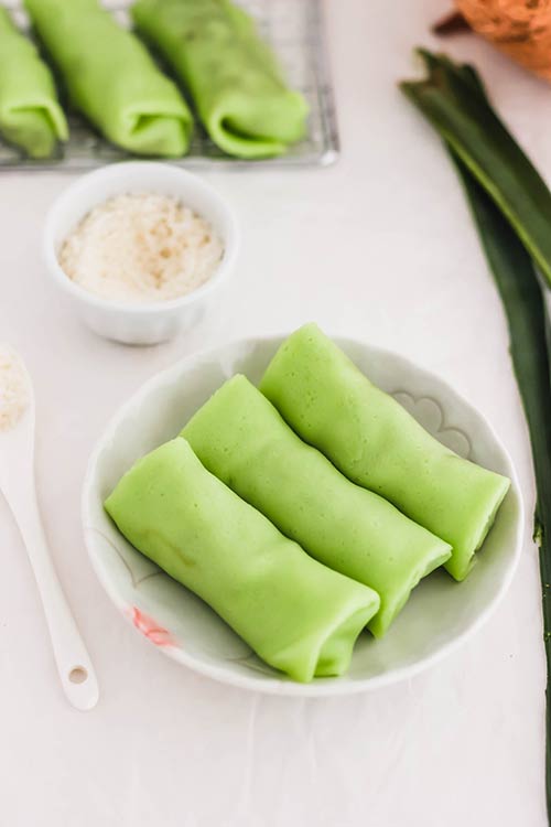 三个绿色kueh达达尔卷椰子pandan绉纱。| www.CuriousCuisiniere.com